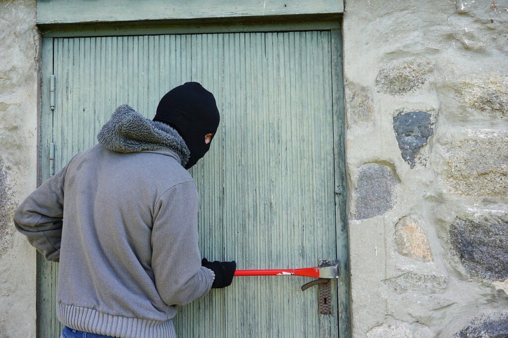 Schutz vor Einbrechern mann bricht Tür auf Brecheisen